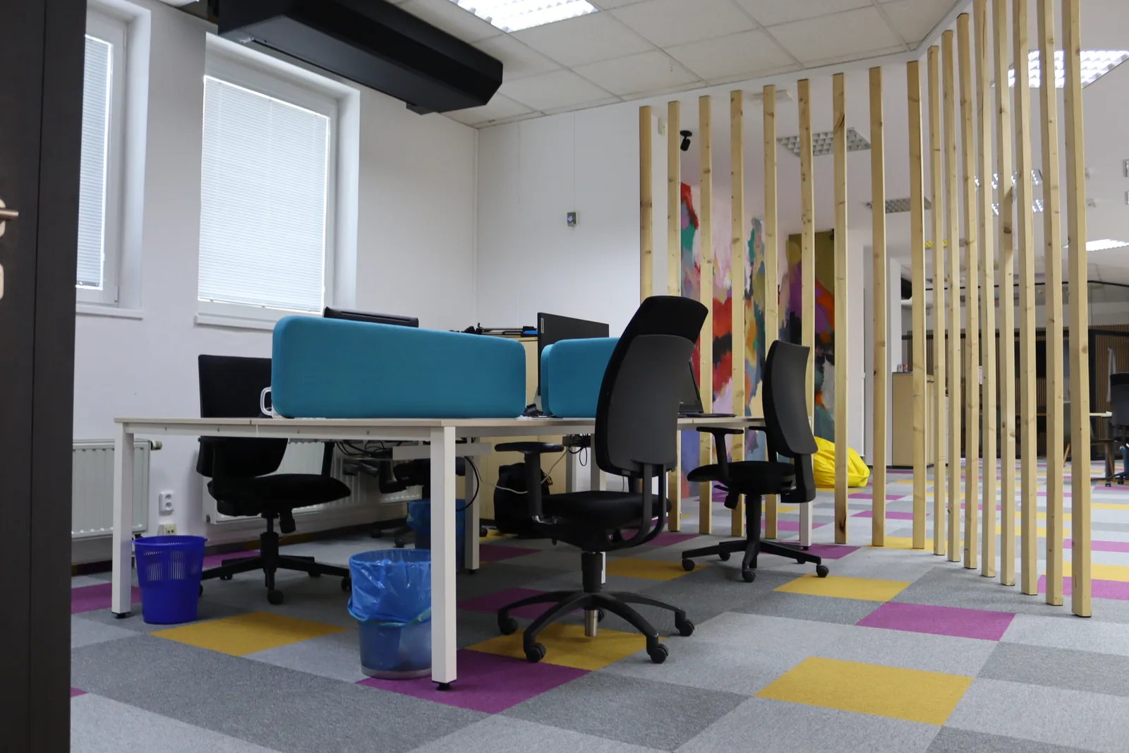 Barevný interiér coworkingu — lounge, murál a pracovní místa
